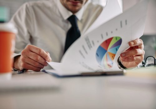 close-up-businessman-analyzing-statistics-while-reading-charts-office-copy-space-scaled.jpg